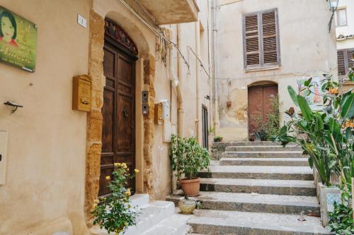 un callejón en un casco antiguo con escaleras y plantas en Il Meraviglioso Mondo di Amélie en Agrigento