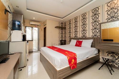 a bedroom with a bed and a tv in it at RedLiving Apartemen Gateway Cicadas - Sarana Cipta Mahakarya in Bandung