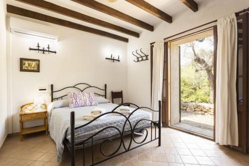 a bedroom with a bed and a large window at Villa Can Salat in Lloseta