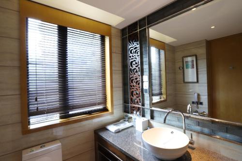 a bathroom with a sink and a mirror at Four Points by Sheraton Heyuan Resort in Heyuan