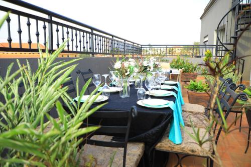 a black table with plates and glasses on a balcony at Galaxy Motel Kampala in Kampala