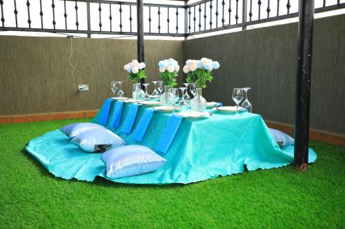 a blue table with pillows and vases on it at Galaxy Motel Kampala in Kampala