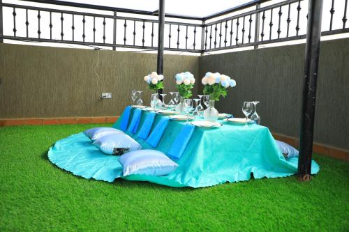 a table with a blue table cloth and flowers on it at Galaxy Motel Kampala in Kampala