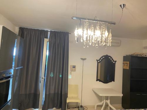 a dining room with a chandelier and a table at Residence La Settima in Milano Marittima