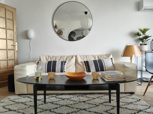 a living room with a couch with a table and a mirror at Massilia Calling love Appartement de standing 8 personnes Marseille proche métro parking facile in Marseille
