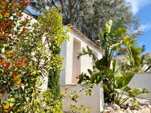 a white house with plants in front of it at Bella Vista Hôtel, Suites & Maisons in Porticcio