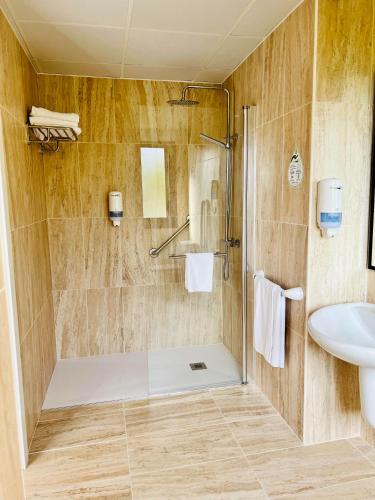 a bathroom with a shower and a sink at Duerming Montalvo Playa Hotel in Montalvo