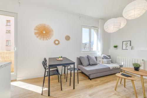un salon avec un canapé et une table dans l'établissement Joli appartement - wifi - Vallier Catane, à Grenoble