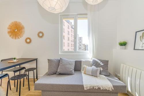 un salon avec un canapé et une table dans l'établissement Joli appartement - wifi - Vallier Catane, à Grenoble