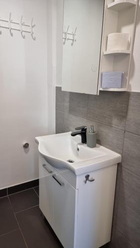 a white bathroom with a sink and a mirror at PARIS in Ljubljana