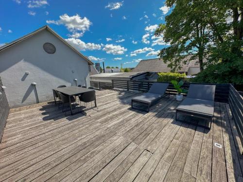 a wooden deck with a table and chairs on it at aday - 3 bedrooms luxurious apartment in Svenstrup in Svenstrup
