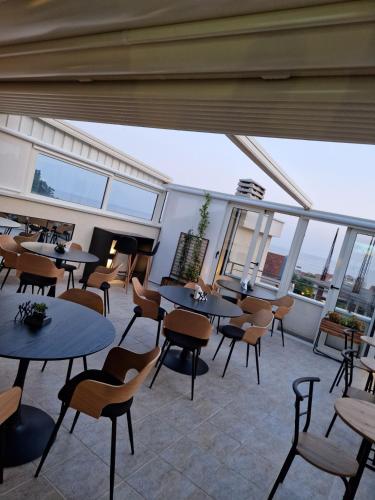 a restaurant with tables and chairs and large windows at Apartmani Marina Kopitovic in Petrovac na Moru