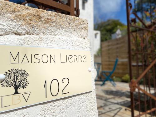 a sign on a stone wall with a mansion licence at Bella Vista Hôtel, Suites & Maisons in Porticcio