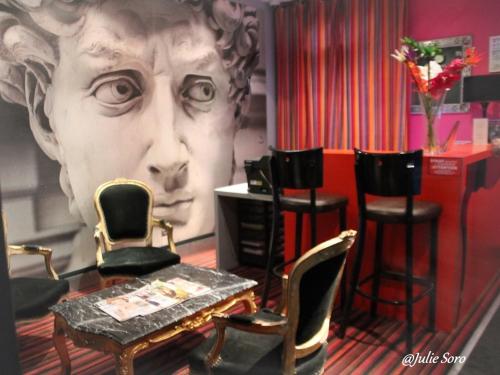 une chambre avec une table et des chaises et une face sur le mur dans l'établissement Hôtel Latino Reims Centre, à Reims