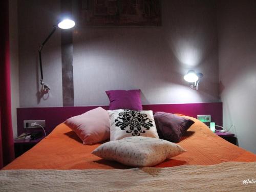 a bedroom with a bed with pillows on it at Hôtel Latino Reims Centre in Reims