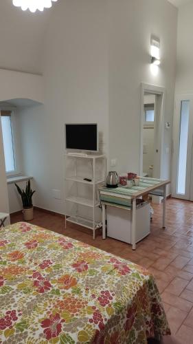 ein Wohnzimmer mit einem TV und einem Tisch mit einem Tisch in der Unterkunft Bed and breakfast Puer Apuliae in Altamura