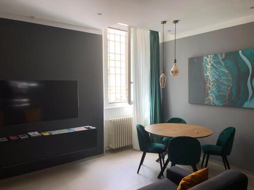 a living room with a table and chairs and a tv at Suite Apollinare in Ravenna