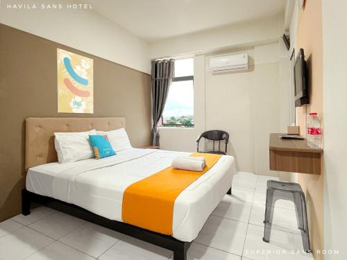um quarto com uma cama e uma televisão em Sans Hotel Havila Bengkulu em Bengkulu