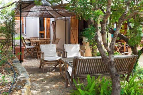 eine Terrasse mit einem Tisch und Stühlen unter einem Sonnenschirm in der Unterkunft Sa Guardia de Ferricci in Solanas