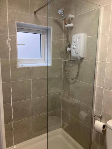een badkamer met een douche en een raam bij Cosy Self Contained Apartment with private bathroom 10 mins to Wembley Stadium in Londen
