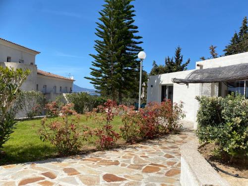 a stone walkway leading to a building with a garden at Bella Vista Hôtel, Suites & Maisons in Porticcio