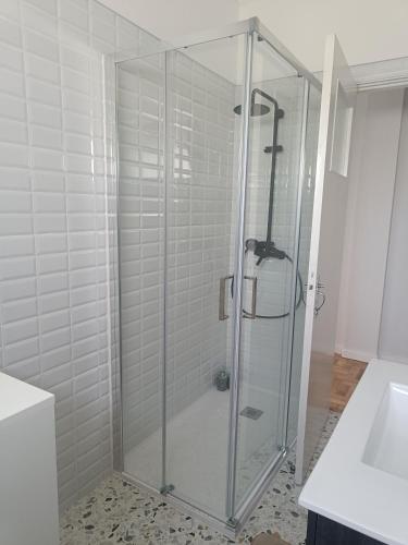 a glass shower in a bathroom with a sink at Casa Mió localizada em pleno centro histórico in Arcos de Valdevez