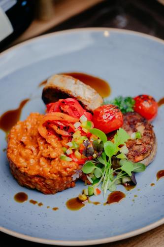 a plate of food with meat and vegetables on it at The Hotel Unforgettable - Hotel Tiliana by Homoky Hotels & Spa in Budapest