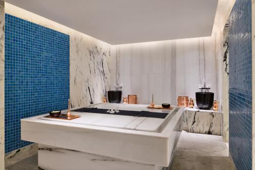 a bath tub in a bathroom with blue tiles at Mulberry Shades Bengaluru Nandi Hills, a Tribute Portfolio Resort in Bengaluru