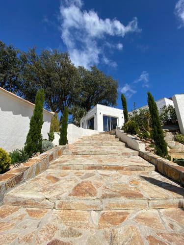 a stone path leading up to a house with trees at Bella Vista Hôtel, Suites & Maisons in Porticcio