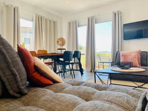 a living room with a couch and a table at Bella Vista Hôtel, Suites & Maisons in Porticcio