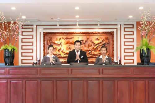 a group of three people sitting at a desk at Poulo Wai Hotel & Apartment in Phnom Penh