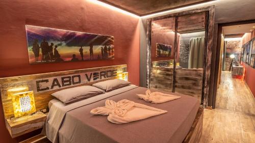 een slaapkamer met een bed met twee handdoeken erop bij Ocean Suites in Santa Maria