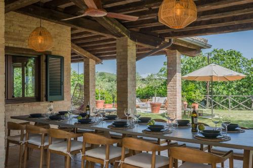 una mesa con sillas y copas de vino en un patio en Villa Sky 14, en Massa Fermana