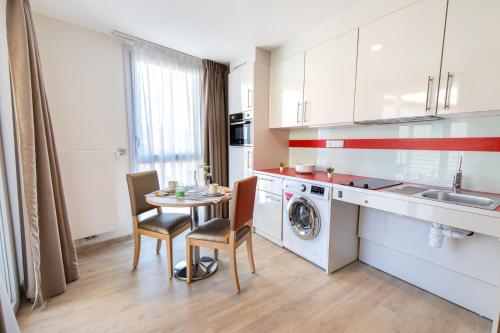 a kitchen with a table and a washing machine at ZENAO Fréjus in Fréjus