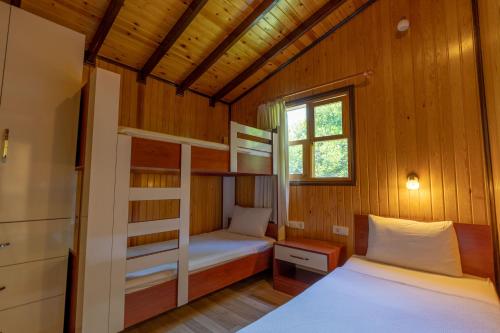 a bedroom with two bunk beds and a window at Caretta Caretta Pension in Cıralı
