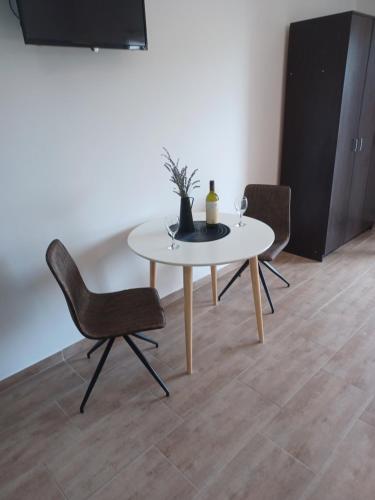 耶爾薩的住宿－Apartmani Miletić，客厅配有一张桌子和两把椅子