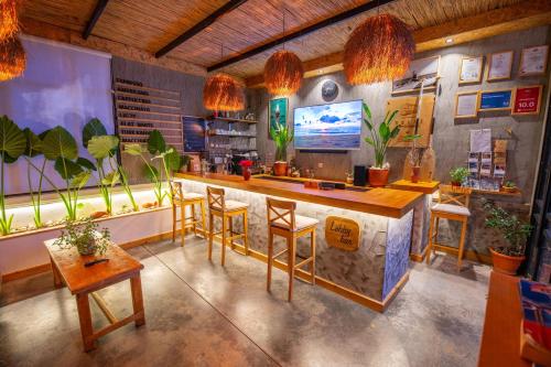 a room with a bar with chairs and plants at Belci City Residence in Fethiye
