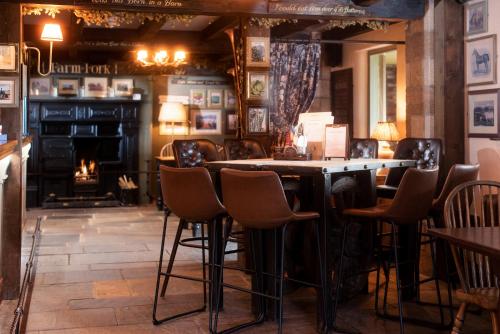 a bar in a restaurant with chairs and a fireplace at The Stables - The Inn Collection Group in Whitby