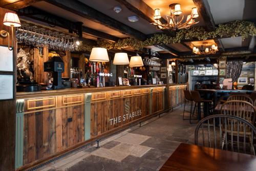 a bar with wooden walls and a table and chairs at The Stables - The Inn Collection Group in Whitby