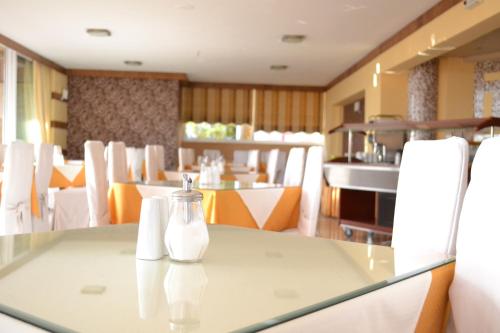 a dining room with a table and white chairs at Palladion in Adelianos Kampos
