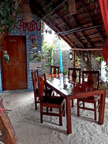 a wooden table and chairs in front of a house at Karibu Paradaizi in Michamvi
