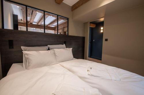 ein großes weißes Bett in einem Zimmer mit Fenstern in der Unterkunft La Maison de l'éclusier in Straßburg