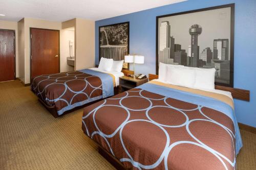 a hotel room with two beds in a room at Super 8 by Wyndham Garland Rowlett East Dallas Area in Garland