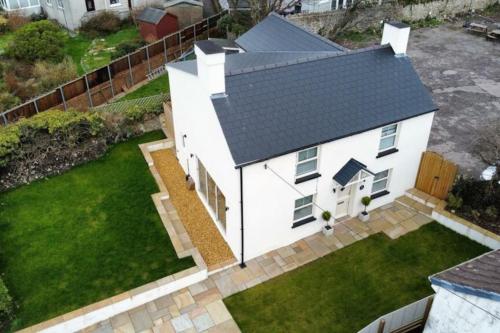 an aerial view of a white house with a yard at Luxury 3 Bedroom Cottage Retreat Near Bridgend Beaches M4 with Garden Workspace Sleeps 6 in Bridgend