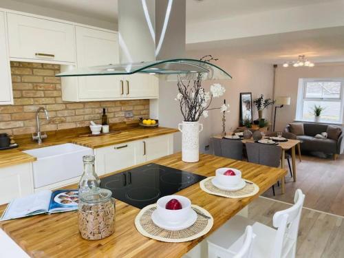 a kitchen and living room with a table with two plates on it at Luxury 3 Bedroom Cottage Retreat Near Bridgend Beaches M4 with Garden Workspace Sleeps 6 in Bridgend