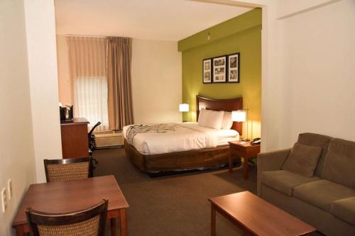 pokój hotelowy z łóżkiem i kanapą w obiekcie Sleep Inn & Suites w mieście Laurel
