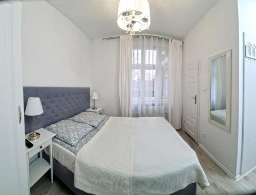 a bedroom with a large bed and a chandelier at Viator in Ustka