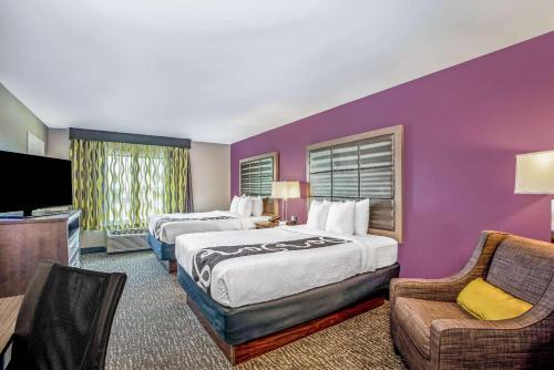 ein Hotelzimmer mit 2 Betten und einer lila Wand in der Unterkunft La Quinta by Wyndham Kearney in Kearney