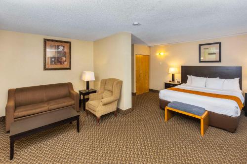 a hotel room with a bed and a chair at Comfort Inn & Suites in Edmonton