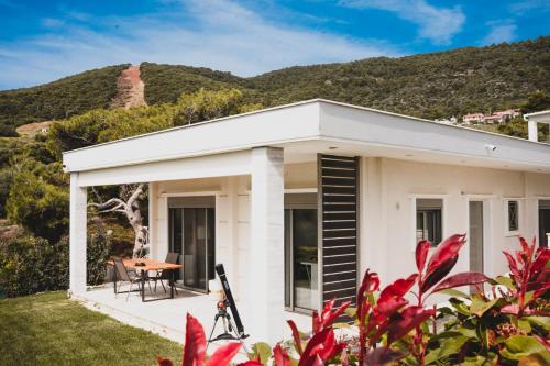 uma casa branca com uma mesa e uma montanha em Greek Sea Villas Kaki Thalassa 400 meters to the beach em Keratea